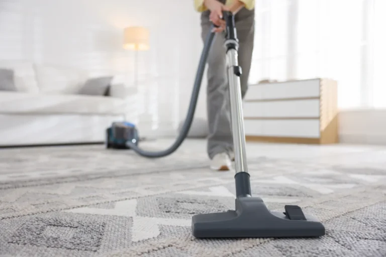 A person cleaning the carpet with a vacuum
